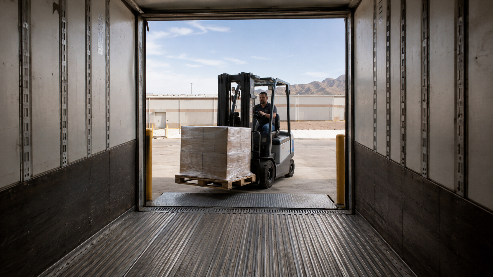 Generic electric forklift approaching an open trailer with a wrapped pallet